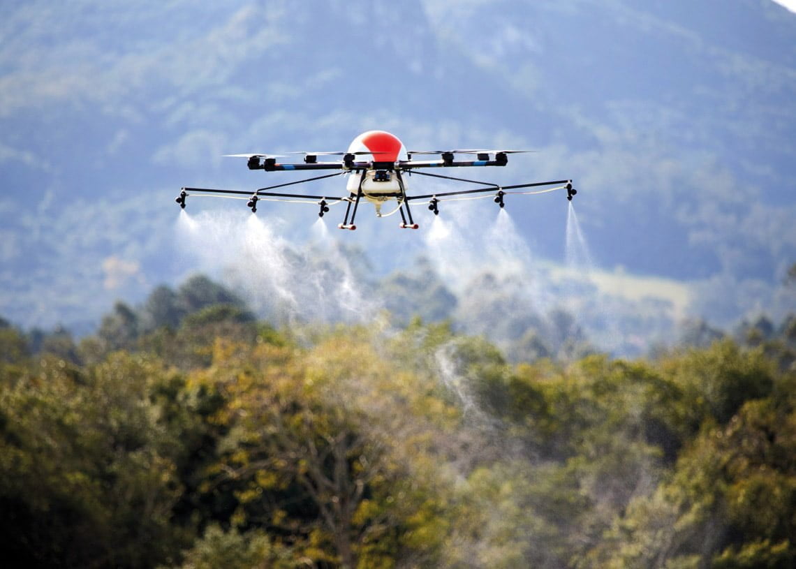 Drone aéreo despejando produto para pulverização